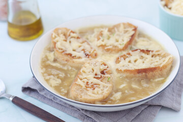 A ceramic bowl with French onion soup	