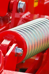 Hard silver spring made of steel. Part of big industrial or agricultural machine