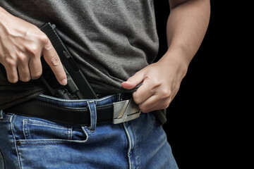 Man drawing a conceal carry pistol from a holster