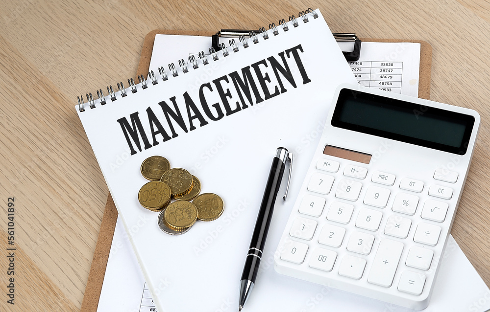Aufkleber management text on a notebook with chart and calculator and coins, business concept