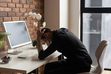 Portrait of stressed businessman with palm on face in his office
