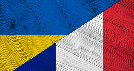 Background with flag of Ukraine and France on wooden split board. 3d illustration