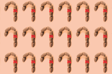 Caramel cane with bow of cedar cones for decoration. Christmas theme. Healthy food and diet food. Pattern