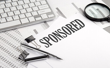SPONSORED text on paper with chart and keyboard, business concept