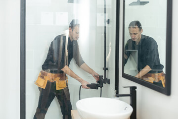 Plumber installing a shower cabin in bathroom