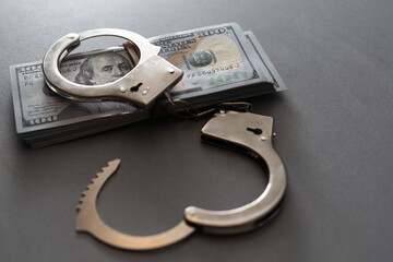 The handcuffs are on hundred-dollar bills. Power and bribery. Criminal ransom. Criminal earnings. Business concept. The concept of wealth.