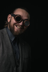 charismatic man in a classic suit and steampunk goggles on a black background stylish Portrait