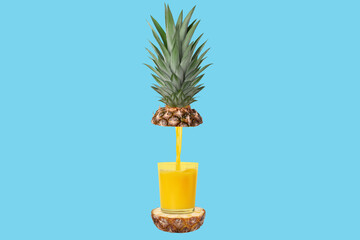 A glass of freshly squeezed pineapple juice. Sliced pineapple around the bottle. In flight. Concept. On a blue background.