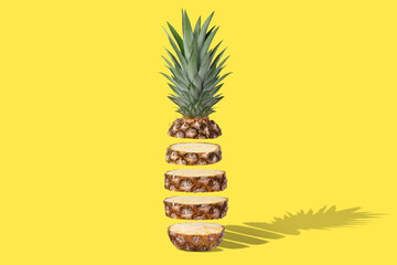 Fresh juicy pineapple in flight cut into rings. On a yellow background.