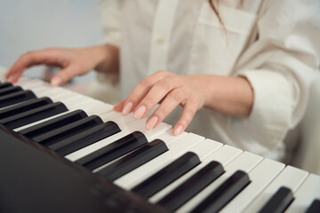 Female composer composing new tune on her synthesizer