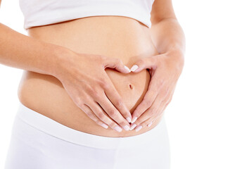 Pregnant woman, hands and heart shape in studio for baby, love and security support in white background studio. Pregnancy wellness, maternity and hand frame abdomen for infant healthcare or growth