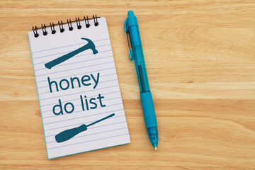 Honey do list on a lined notepad with hammer and screwdriver
