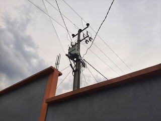 Electric cable and pole on a gloomy day or overcast sky,