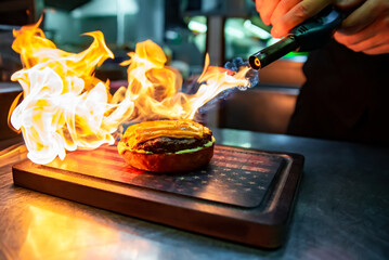chef hand preparing a gourmet burger on restaurant kitchen step by step