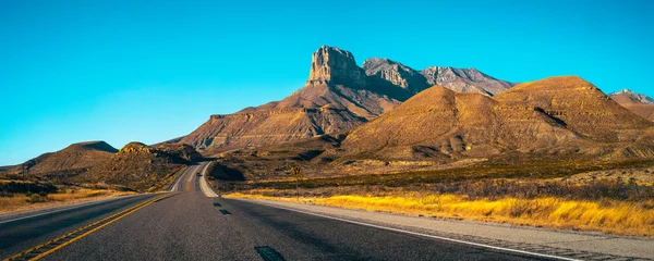 Fototapete Fotos Guadalupe Mountains National Park landscape near El Captain Viewpoint on Route 62 in Salt Flat, Dell City, Texas, USA, panoramic retro-style autumn road scenery with golden grasses  © Naya Na
