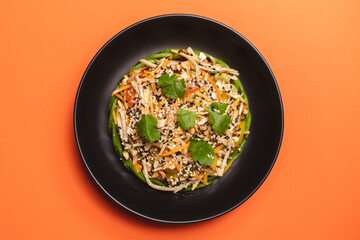 Hearty breakfast in a black plate on an orange background. View from above. Food photography.