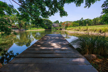 A wooden bridge extend into a pond.