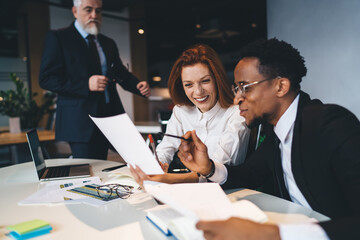 Fototapeta premium Positive multiethnic colleagues working in modern office