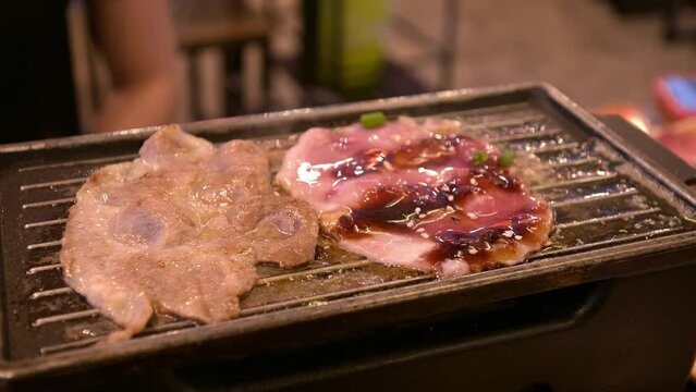 4K, Charcoal grilled Kobe Wagyu beef sliced Yakiniku , gourmet Japanese-style bbq. Cooking grill beef on net grilled in restaurant. Thinly sliced wagyu beef on grille for barbecue. meat cuisine.