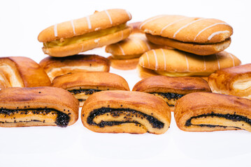 Delicious sweet buns with jam and poppy seeds. And cream pies. On a white isolated background.