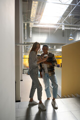Fototapeta premium Two friends looking at phone screen while standing in the office hall