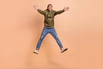 Fototapeta na wymiar Full length photo of overjoyed positive man wear stylish outfit open hands glad see you good mood isolated on beige color background