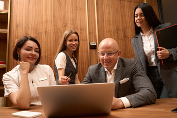 Young woman in office clothes pointing at laptop screen