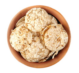 Brown rice crisps, chips pile with chia seeds and quinoa in clay pot isolated on white, top view 