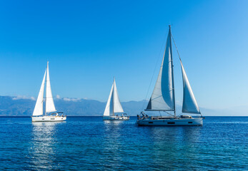Fototapeta na wymiar sailing yacht boats with white sails in blue sea , seascape of beautiful ships in sea gulf with mountain coast on background