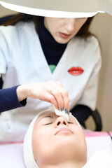 Obraz na płótnie Canvas Procedure at a cosmetologist, cleansing the face of cosmetics and preparing the face for massage.