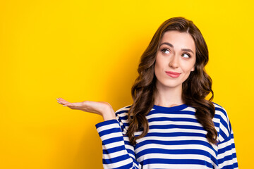 Photo portrait of pretty young girl look interested empty space dressed stylish striped clothes isolated on yellow color background