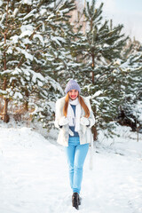 Fototapeta na wymiar Kyiv, Ukraine. January 13, 2023: Winter trip to the lake. A white scarf, warm pants and a sincere smile. The joy of life. Europe in winter