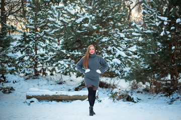 Vinnytsia, Ukraine. January 12, 2023: A snowy coniferous forest in January in Ukraine. Portrait of a girl near the Christmas tree in a warm dress. Alps, Canada. Copy space