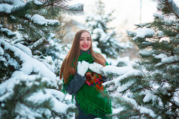 Vinnytsia, Ukraine. January 10, 2022: Green bright scarf with red flowers as a traditional clothing of girls in Ukraine. Smile of a blonde in winter. It's 15 degrees outside