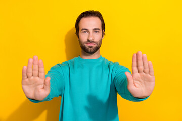 Photo of serious veto against young man show restriction symbol palms wear blue sweater confident...