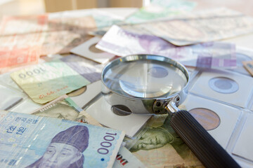 Different old collectors coins, banknotes and magnifying glass