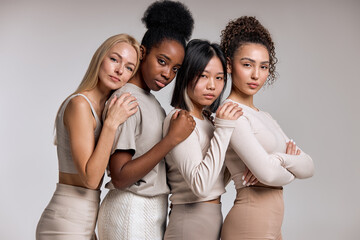 Female Beauty. Four Multiracial Women Looking At Camera Posing In Studio On White Background....