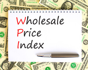 WPI wholesale price index symbol. Concept words WPI wholesale price index on white note on a beautiful background from dollar bills. Business WPI wholesale price index concept. Copy space.