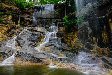 Obraz premium Beautiful waterfall on small river in a park