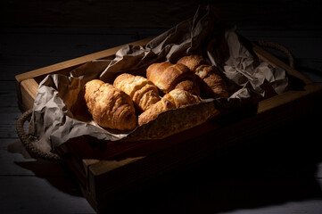 Fresh baked croissants lie on the table in the kitchen 
