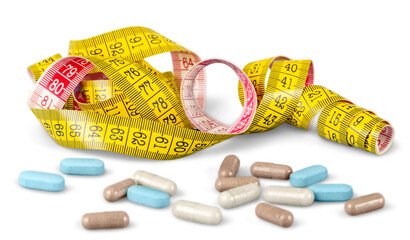 Yellow measuring tape and medicines pills