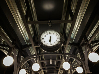 old station clock on a dark background with a white dial