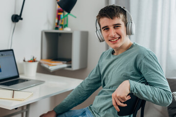 Fototapeta premium Boy sitting in front of his desk and looking at the camera