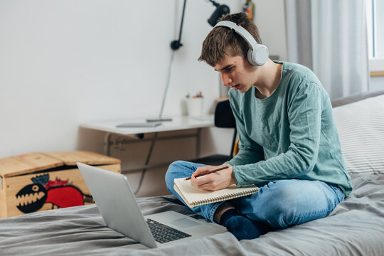 High School Student Takes Notes In The Online Class