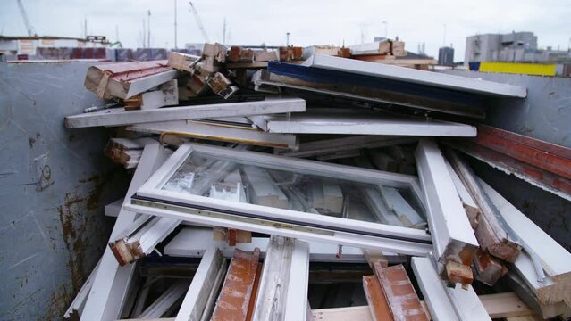Scrap windows and frames inside dump. Tilt up.