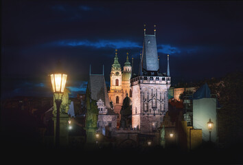 Fototapeta na wymiar Charles Bridge at night with Lesser Town Bridge Tower and St. Nicholas Church - Prague, Czech Republic