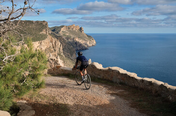 Fit male cyclist riding dirt trails on gravel bike.
Man riding gravel bike on gravel road in scenic...