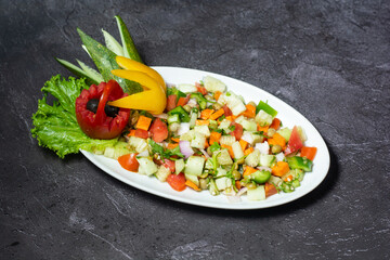 Fototapeta na wymiar Fresh green salad with cucumber, tomato, onion, carrot served in dish isolated on grey background top view of indian and bangladesh food