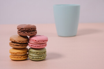 macarons of different colors and flavors on a background with pastel colors
