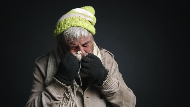 Portrait of adult, caucasian man in his 60s looking ill and moody. Close-up shot of a senior, homeless adult crying. High quality 4k footage